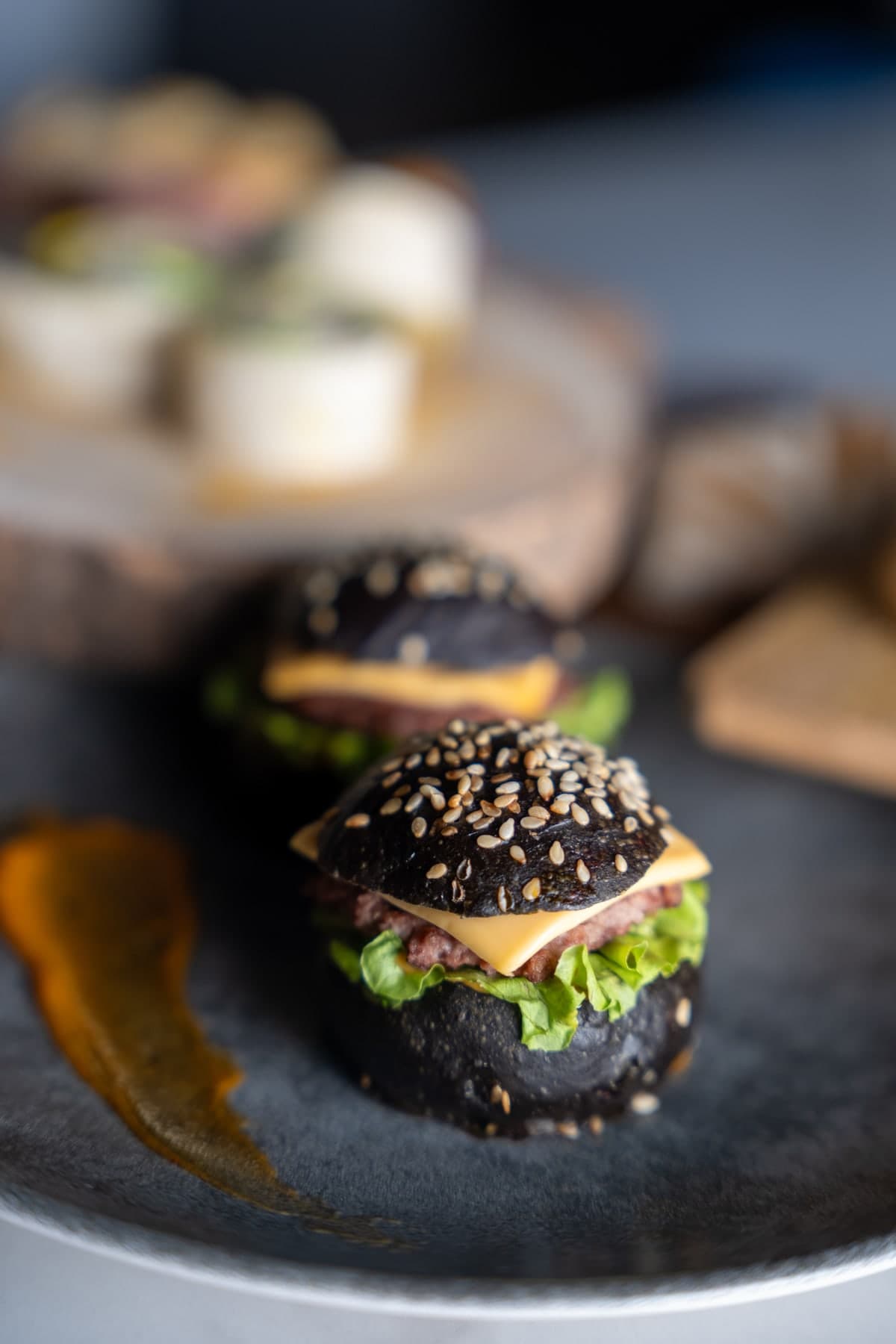 Mini-burger sésame noir sur ardoise : la pièce cocktail qui attire l'œil — Ô Fines Bouchées
